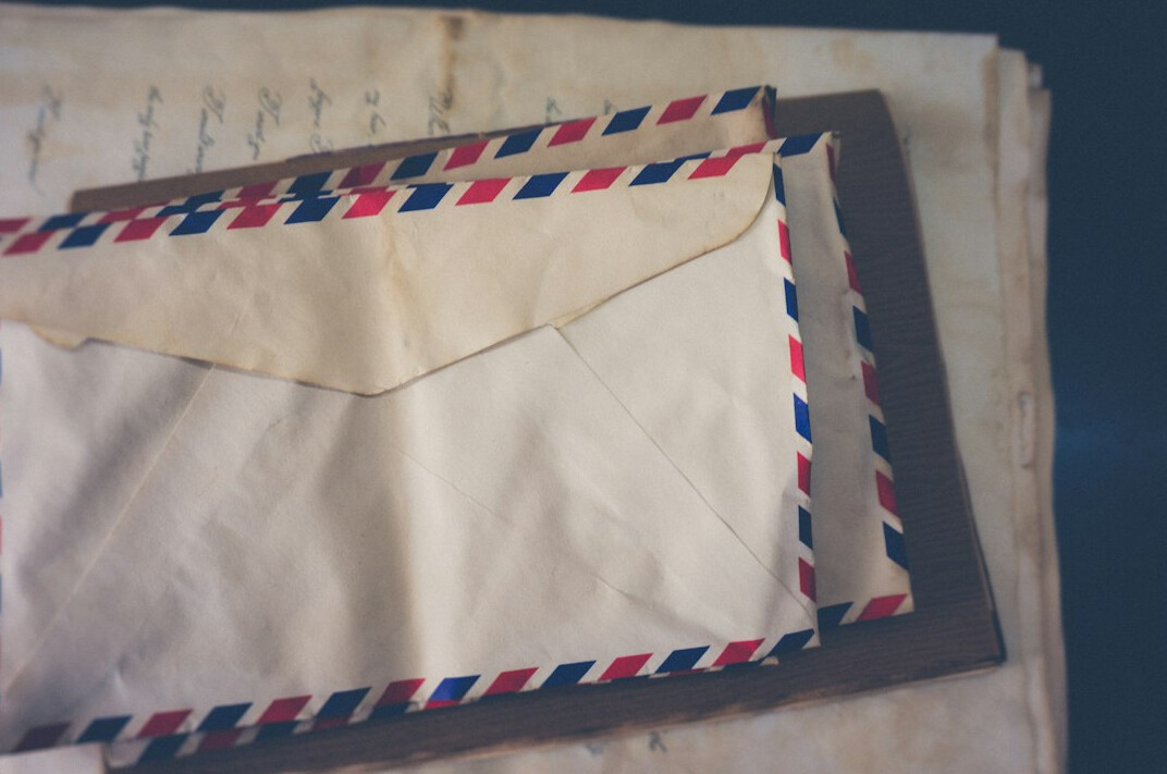Stack of old documents and sealed envelopes on a wooden table